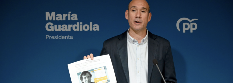 El portavoz del PP de Extremadura, José Ángel Sánchez Juliá, enseña una foto del hermano del presidente del Gobierno