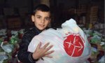 Un niño recibe alimentos en una campaña de ayuda a familias cristianas de ACN en Mosul (Irak)