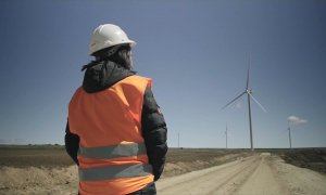 Mujer de espaldas con molinos de fondo