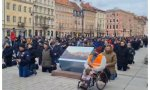 Centenares de hombres arrodillados rezando en las calles de Varsovia (Polonia) por la paz en Ucrania
