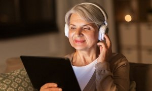 anciana con auriculares y tablet